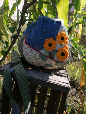 La caraboule , Besace ronde , "le soleil partout", motifs tournesol crocheté, jean , cotons, et  tissus tapissier