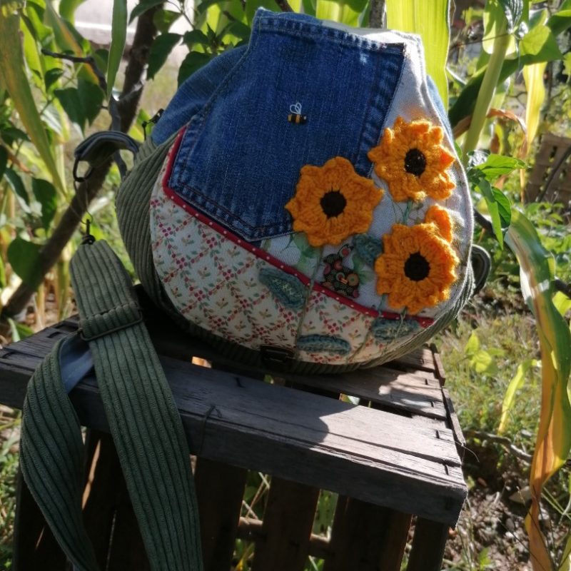La caraboule , Besace ronde , « le soleil partout », motifs tournesol crocheté, jean , cotons, et tissus tapissier