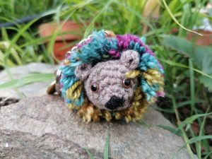 Amigurumi Porte-clés hérisson, gris à la crinière coloré et  bouton prune et doré, crochet et pom-pom